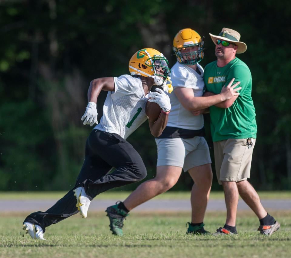 Koby Howard (1) carries the ball during football practice at Pensacola Catholic High School in Pensacola on Monday, April 25, 2022.