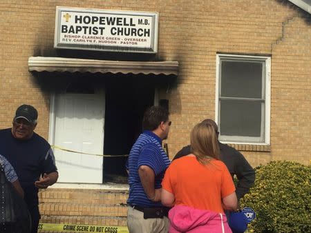 People gather in front of Hopewell Baptist Church that was damaged by fire and graffiti in Greenville, Mississippi, U.S., November 2, 2016. Courtesy Angie Quezada/Delta Daily News via REUTERS