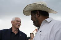 Former Vice President Mike Pence talks with Juan Pina, right, during a visit to the Iowa State Fair, Friday, Aug. 19, 2022, in Des Moines, Iowa. (AP Photo/Charlie Neibergall)