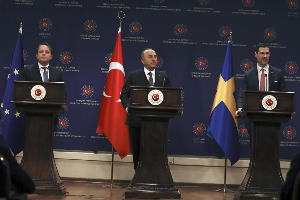 El canciller turco Mevlut Cavusoglu; centro, el comisionado europeo para Vecindad y Ampliación, Oliver Varhelyi, izquierda; y el ministro de Cooperación Internacional de Suecia, Johan Forssell, hablan en conferencia de prensa conjunta en Ankara, Turquía, miércoles 22 de febrero de 2023. En marzo se realizará una Conferencia Internacional de Donantes en Bruselas. (AP Foto/Burhan Ozbilici)