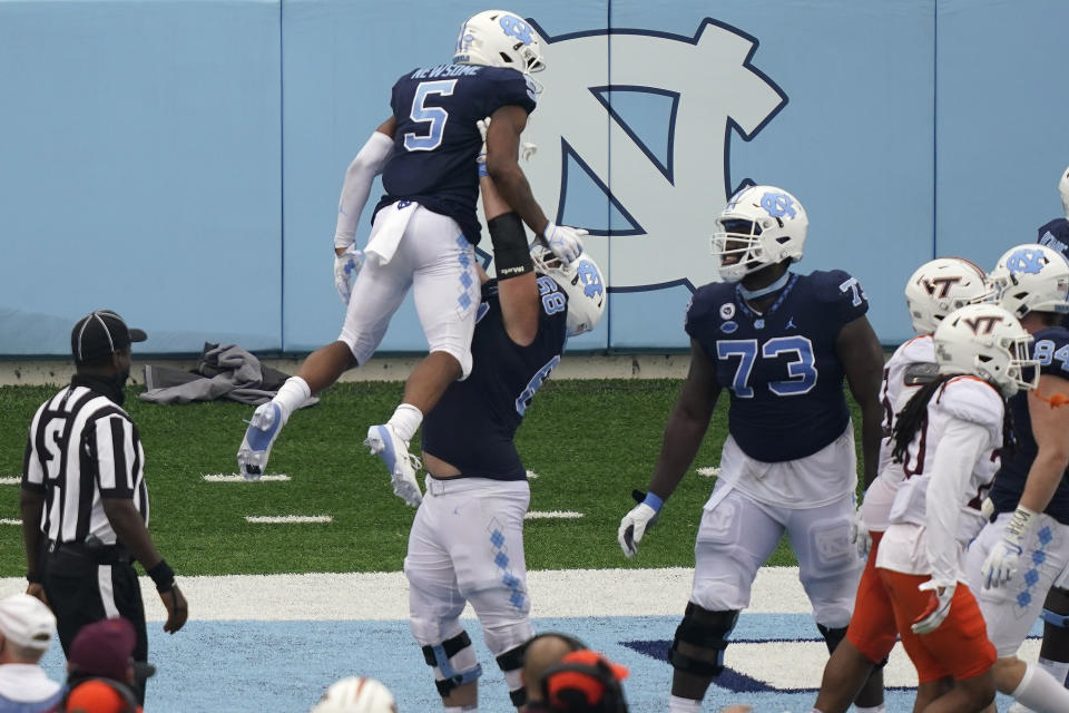 North Carolina offensive lineman Brian Anderson (68) lifts wide receiver Dazz Newsome (5) following Newsome's touchdown against Virginia Tech during the second half of an NCAA college football game in Chapel Hill, N.C., Saturday, Oct. 10, 2020. (AP Photo/Gerry Broome)