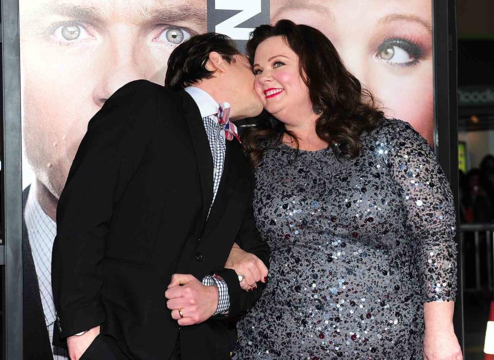 Ben Falcone (L) kisses Melissa McCarthy while posing on arrival for the World Premiere of the film 'Identity Thief' in Los Angeles, California, on February 4, 2013. The films opens nationwide on February 8