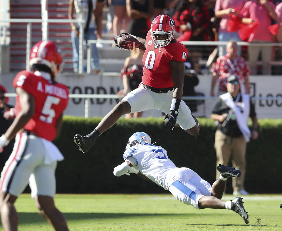 Georgia tight end Darnell Washington leaps over Kentucky defender DeAndre Square for a first down during the first quarter of an NCAA college football game against Kentucky, Saturday, Oct. 16, 2021, in Athens, Ga. (Curtis Compton/Atlanta Journal-Constitution via AP)