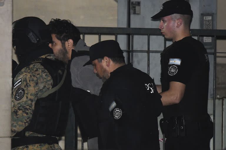 Fernando Sabag Montiel, center left, is brought in by the police to the Federal Court building on Comodoro Py Avenue, to testify as the main suspect in the attempted murder of Argentine Vice President Cristina Fernandez, in Buenos Aires, Argentina, Tuesday, Sept. 6, 2022. Sabag Montiel was quickly arrested after he pointed and seemingly attempted to fire a handgun at Vice President Fernandez's face as she arrived home surrounded by a throng of supporters. (AP Photo/Gustavo Garello)