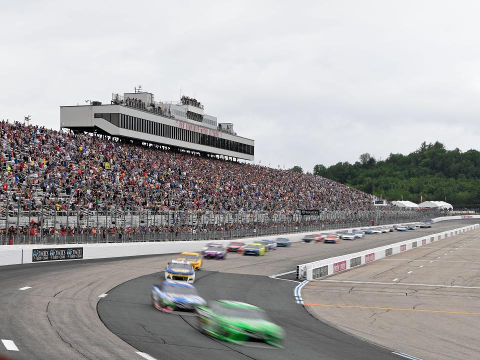 Kyle Busch leads the pack into Turn 1 at the start of the 2021 NASCAR Cup Series race at New Hampshire Motor Speedway.