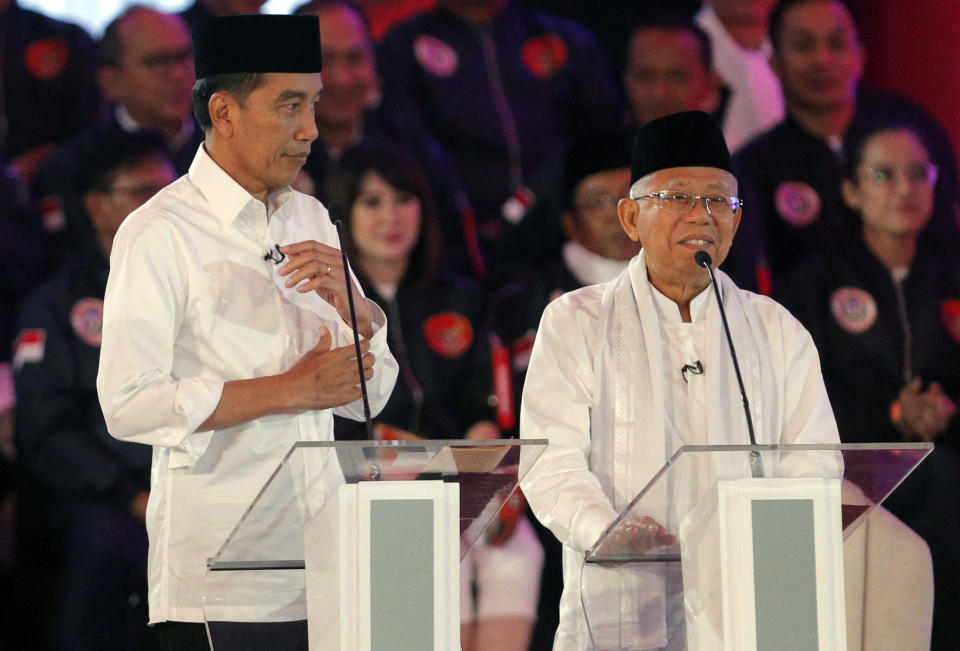 Indonesian President Joko Widodo, left, listens with running mate Ma'ruf Amin delivers a speech during a televised debate in Jakarta, Indonesia, Thursday, Jan. 17, 2019. Indonesia is gearing up to hold its presidential election on April 17 that will pit in the incumbent against the former general.(AP Photo / Tatan Syuflana)