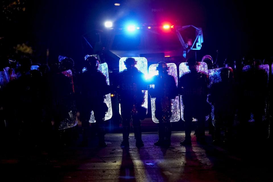 CORRECTS TO JOHN CHISHOLM NOT JOHN CHISOLM - Police line up in riot gear Friday, Oct. 9, 2020, in Wauwatosa, Wis. On Wednesday, District Attorney John Chisholm refused to issue charges against Wauwatosa Police Officer Joseph Mensah for the Feb. 2 fatal shooting of 17-year-old Alvin Cole at Mayfair Mall. (AP Photo/Morry Gash)