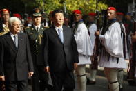 China's President Xi Jinping, centre and his Greek counterpart Prokopis Pavlopoulos, left, inspect the guard of honor by Evzones, the Greek Presidential guards, outside the Presidential palace in Athens, Monday, Nov. 11, 2019. Xi Jinping is in Greece on a two-day official visit. (AP Photos/Thanassis Stavrakis)