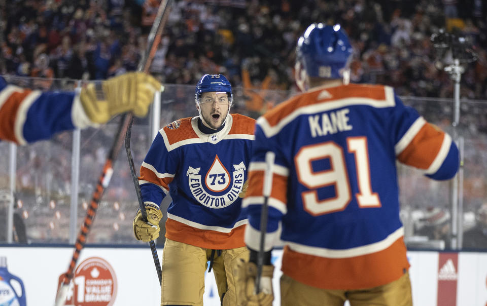 Edmonton Oilers' Vincent Desharnais (73) and Evander Kane (91) celebrate after a goal against the Calgary Flames during third-period NHL Heritage Classic outdoor hockey game action in Edmonton, Alberta, Sunday, Oct. 29, 2023. (Jason Franson/The Canadian Press via AP)
