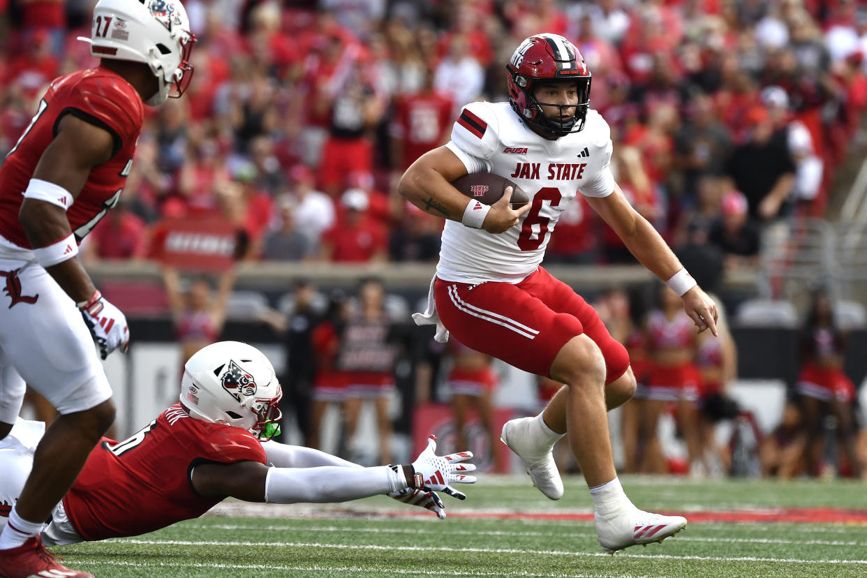 Louisville linebacker Stanquan Clark (6) attempts to grab Jacksonville State quarterback Tyler Huff (6) during the first half of an NCAA college football game in Louisville, Ky., Saturday, Sept. 7, 2024. (AP Photo/Timothy D. Easley)