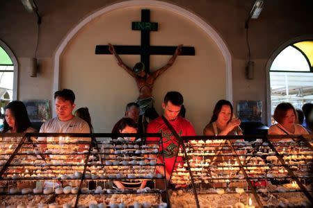 Filipino Catholic devotees light candles and offer prayers after attending a mass at a National Shrine of Our Mother of Perpetual Help in Baclaran, Paranaque city, metro Manila, Philippines September 18, 2016. REUTERS/Romeo Ranoco