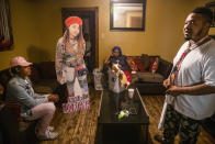 Brione Rogers sits on the couch next to a cutout of her cousin Todriana Peters and Peters' mother Katrina Lambert and father Todd Peters in New Orleans, Thursday, July 8, 2021. Twelve-year-old Todriana Peters was shot and killed outside a graduation party on Memorial Day Weekend in the Lower 9th Ward neighborhood. Homicide rates in many American cities have continued to rise although not as precipitously as the double-digit jumps seen in 2020 and still below the violence of the mid-90s. (AP Photo/Sophia Germer)