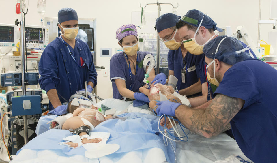 This photo provided by RCH Melbourne Creative Studio, shows surgery on the 15-month-old girls at the Royal Children's Hospital Melbourne, Australia Friday, Nov. 8, 2018. Surgeons in Australia have begun separating the conjoined twins from Bhutan in a delicate operation expected to last most of the day. (RCH Melbourne Creative Studio via AP)