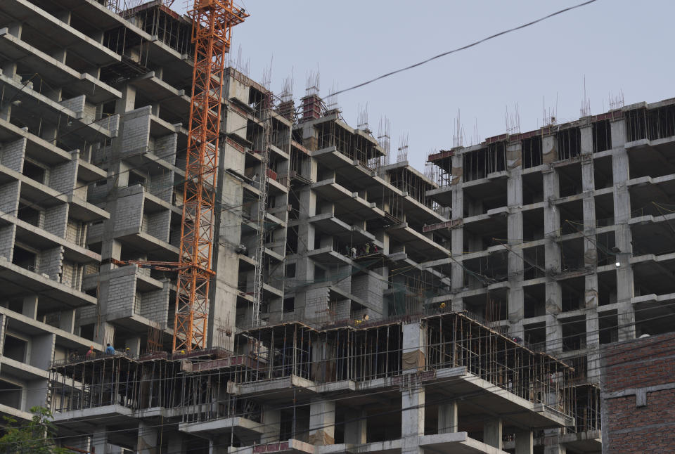 Laborers work on the construction of a residential apartment in Hyderabad, India, Wednesday, Aug. 31, 2022. India’s economy grew by 13.5% in the April-June quarter from a year earlier, pushed up by a boost in agriculture and manufacturing as pandemic curbs eased, official figures released Wednesday show. (AP Photo/Mahesh Kumar A.)