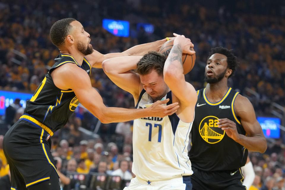 West finals: Mavericks guard Luka Doncic (77) tries to drive under pressure from Warriors defender Stephen Curry (30) during the first half of Game 1.