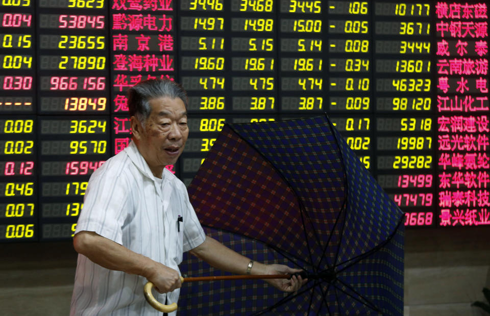 An investor folds his umbrella at a private securities company Tuesday, Sept. 4, 2012, in Shanghai, China. Asian stock markets fell Tuesday as uncertainty persisted about what authorities in the U.S., China and Europe might do to deal with a souring global economy. (AP Photo)