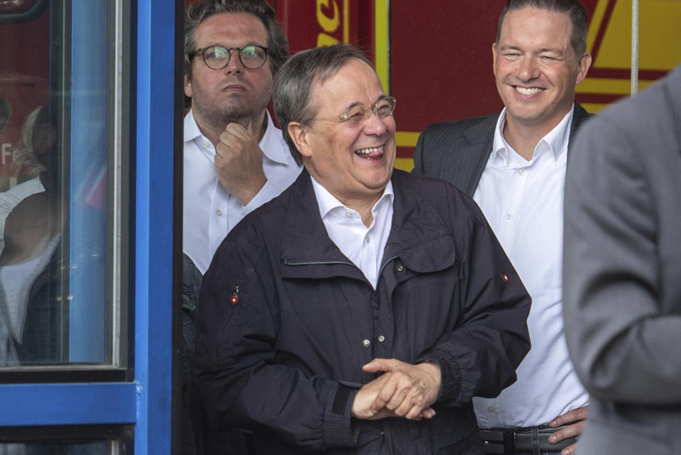 FILE - In this Saturday, July 17, 2021 file photo, Armin Laschet, center, Governor of the German state of North Rhine-Westphalia and the top candidate of the German Christian Democrats for the upcoming federal elections, laughs in Erftstadt, Germany, while German President Steinmeier gives a press statement on the floodings in Germany. Germany's election campaign has largely focused on the three candidates hoping to succeed Angela Merkel as chancellor after four terms in office, Annalena Baerbock for the Greens, Armin Laschet for the Christian Union parties and Olaf Scholz for the Social Democrats. German elections will be on Sept.26. (Marius Becker/ Pool via AP, File)