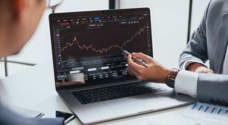 A couple looks at their portfolio on a computer. Deutsche Bank writes that the stock market could see a return to value investing as interest rates rise.