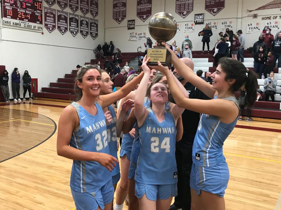 Mahwah girls basketball players Payton Nista (32), Gianna Lotito (24) and Carissa Weber hoist the Bergen Invitational Tournament trophy after the Thunderbirds defeated Park Ridge, 40-33 in double overtime. Friday, Feb. 25, 2022 at Park Ridge High School.