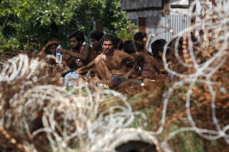 Migrants who were found at sea on a boat sit near Kanyin Chaung jetty after landing outside Maungdaw township, northern Rakhine state, Myanmar, June 3, 2015. REUTERS/Soe Zeya Tun