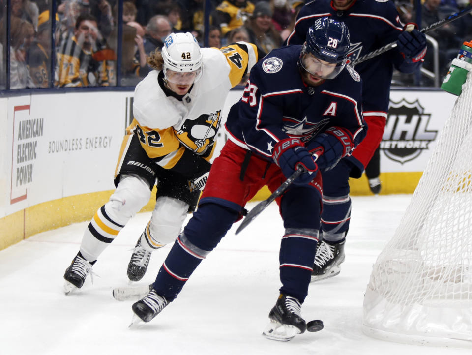 Columbus Blue Jackets forward Oliver Bjorkstrand, right, chases the puck in front of Pittsburgh Penguins forward Kasperi Kapanen during the first period of an NHL hockey game in Columbus, Ohio, Friday, Jan. 21, 2022. (AP Photo/Paul Vernon)