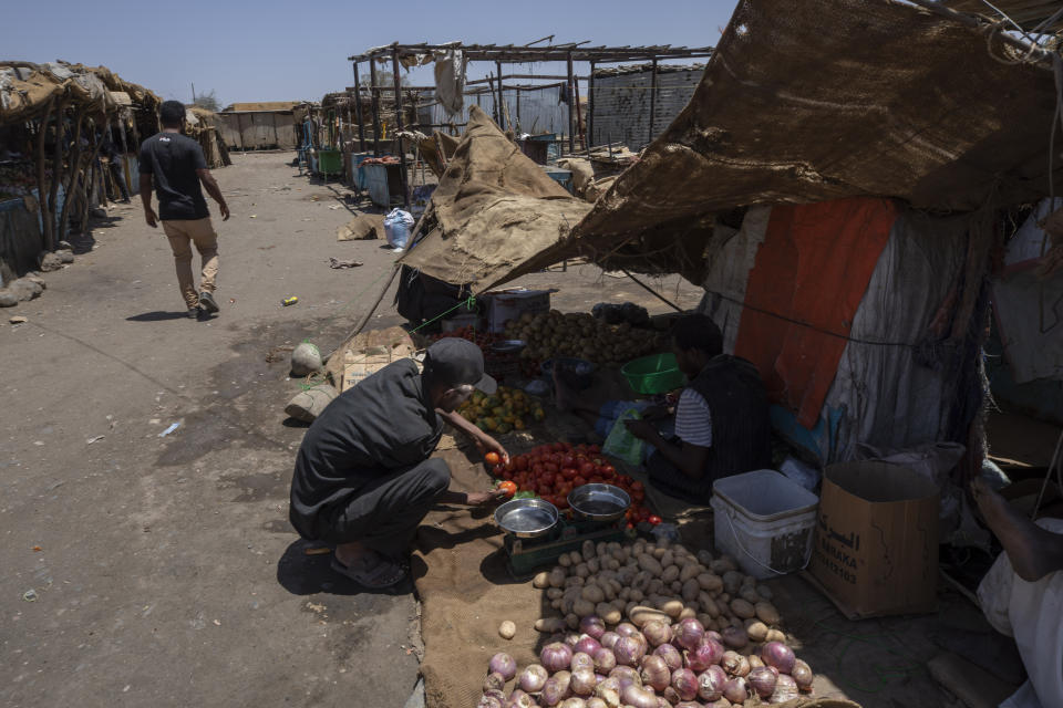 Abraha Kinfe Gebremariam, un refugiado de Tigray de 40 años, compra tomates en un mercado en Hamdayet, en el este de Sudán, cerca de la frontera con Etiopía, el 21 de marzo de 2021. Un día, durante el conflicto en su aldea de Etiopía, su hijo Daniel trató de ir al mercado y vio unos 10 cuerpos apilados en un vehículo para ser enterrados. Luego vio otros cuatro en el piso. Daniel nunca volvió al mercado. (AP Foto/Nariman El-Mofty)