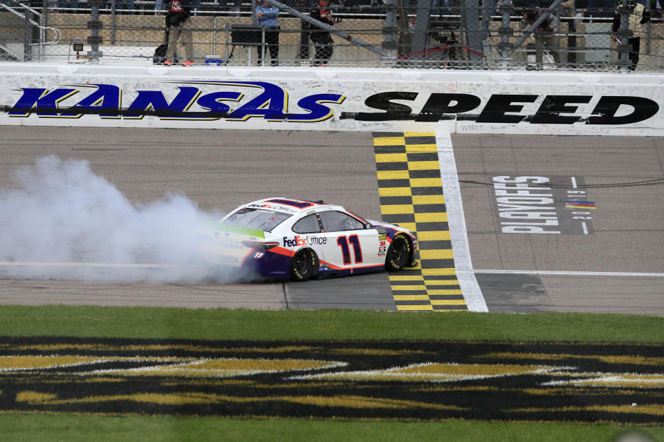 Denny Hamlin (11) celebrates after winning a NASCAR Cup Series auto race at Kansas Speedway in Kansas City, Kan., Sunday, Oct. 20, 2019. (AP Photo/Orlin Wagner)