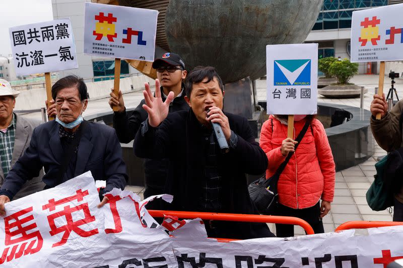 A protester speaks to the media against Former Taiwan President Ma Ying-jeou's visit to China outside the airport in Taoyuan