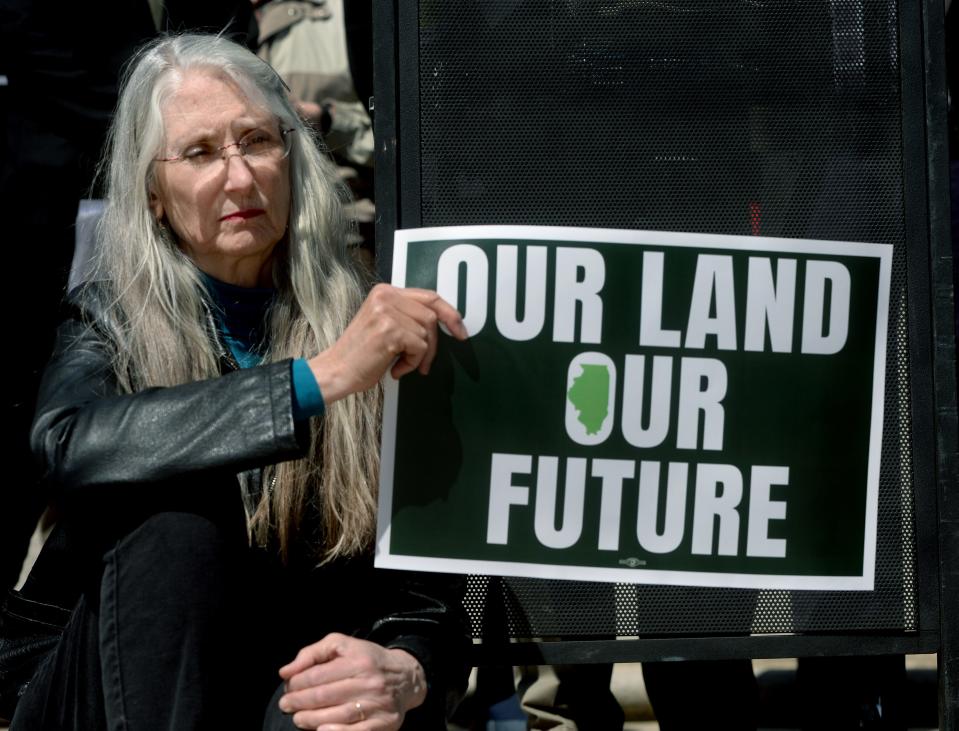 Dawn Dannenbring of Bloomington holds up a sign protesting carbon dioxide pipelines during a press conference in front of the state Capitol Tuesday, May 2, 2023.