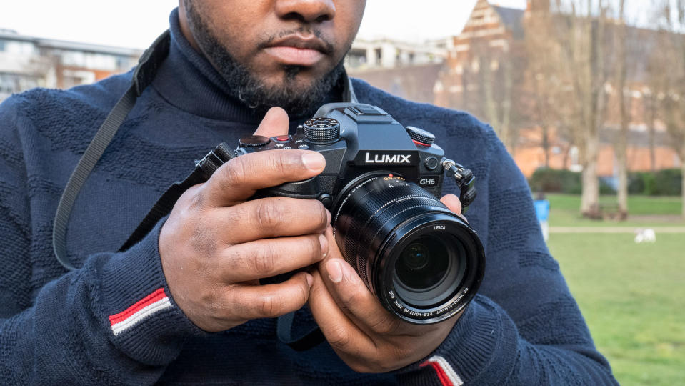 Panasonic Lumix GH6 being held by reviewer Jon Devo