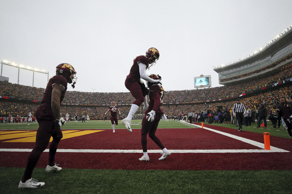 Minnesota wide receiver Tyler Johnson (6) jumps up in the air to celebrate with teammate wide receiver Rashod Bateman (13) after Bateman scored a touchdown against Wisconsin during an NCAA college football game Saturday, Nov. 30, 2019, in Minneapolis. (AP Photo/Stacy Bengs)