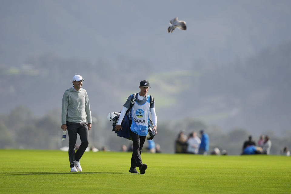 Scottie Scheffler, left, walks with his caddie up the 14th fairway at Pebble Beach Golf Links during the second round of the AT&T Pebble Beach National Pro-Am golf tournament in Pebble Beach, Calif., Friday, Feb. 2, 2024. (AP Photo/Ryan Sun)
