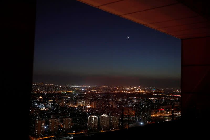 Moon shines above buildings in Beijing