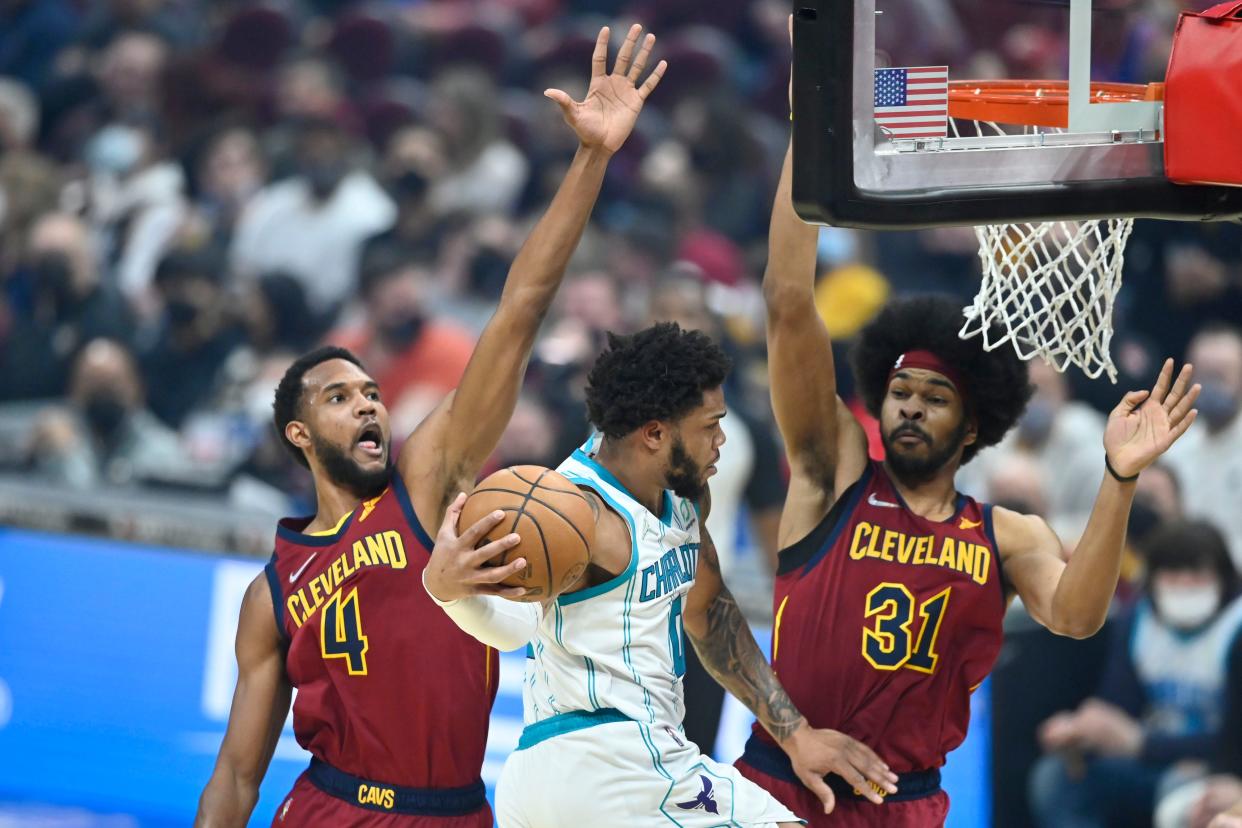 Mar 2, 2022; Cleveland, Ohio, USA; Charlotte Hornets forward Miles Bridges (0) moves between Cleveland Cavaliers center Evan Mobley (4) and center Jarrett Allen (31) in the first quarter at Rocket Mortgage FieldHouse. Mandatory Credit: David Richard-USA TODAY Sports