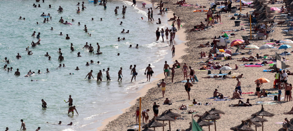 Tourists sunbathe and swim at the beach of Magaluf on the island of Mallorca, Spain, August 18, 2017. Picture taken August 18, 2017. REUTERS/Enrique Calvo