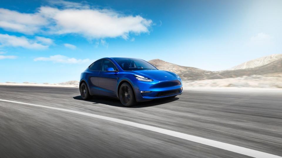 A blue Tesla car driving on an open road.
