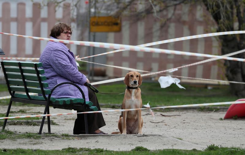 A view shows a woman and a dog on a taped-off playground amid the outbreak of the coronavirus disease in Moscow