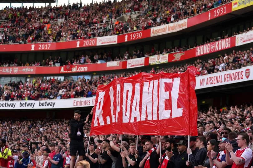 Fans hold up a banner on the 14th minute in memory of 14-year-old Daniel Anjorin, who died following the sword attack in east London on Tuesday