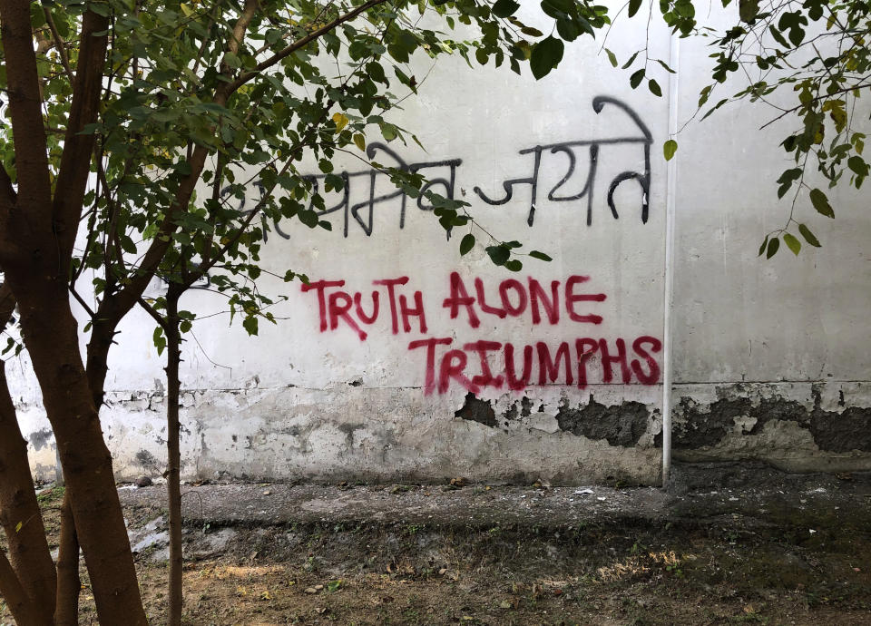 In this Wednesday, Dec. 18, 2019 photo, a graffiti covers the wall of a building at Jamia Millia Islamia University in New Delhi, India. Students of this New Delhi university have turned the campus' sandstone walls into a canvas of discontent. The spray-painted slogans and symbols reflect their opposition to a new law that provides a path to citizenship for religious groups from neighboring countries except Muslims. (AP Photo/Sheikh Saaliq)