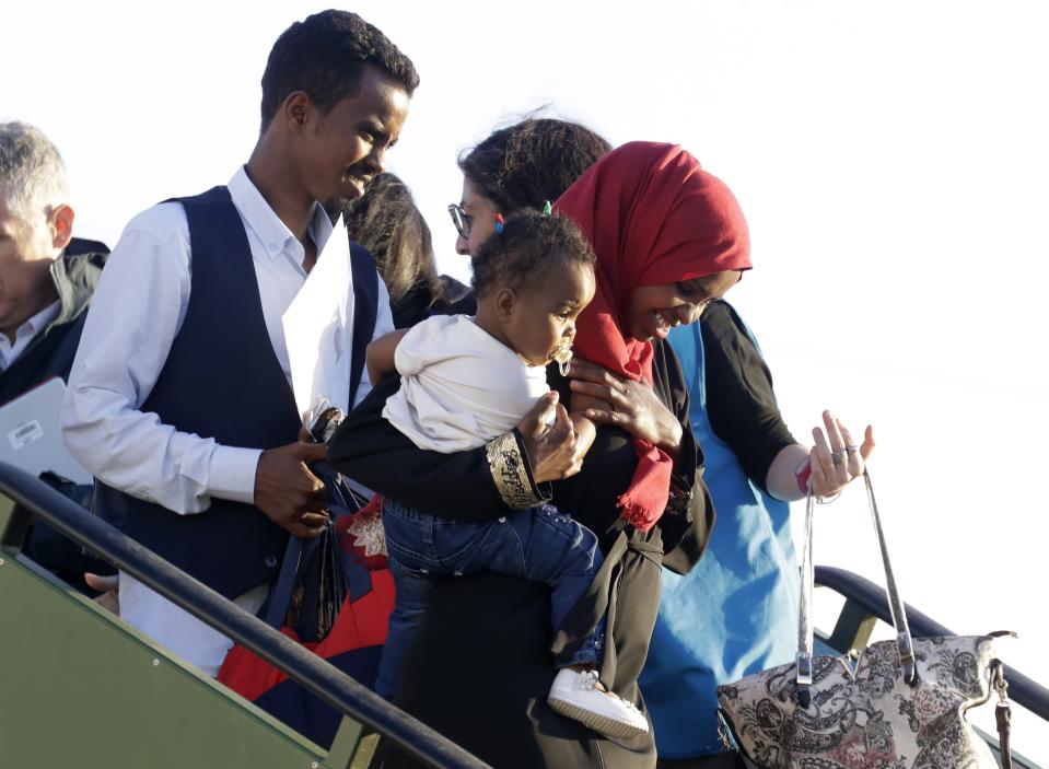 A family disembarks from an Italian military aircraft arriving from Misrata, Libya, at Pratica di Mare military airport, near Rome, Monday, April 29, 2019. Italy organized a humanitarian evacuation airlift for a group of 147 asylum seekers from Ethiopia, Eritrea, Somalia, Sudan and Syria. (AP Photo/Andrew Medichini)