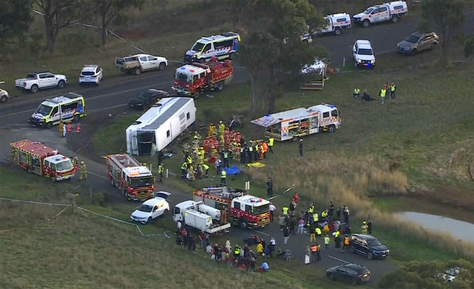 In this image made from video, rescue workers help children from a school bus that rolled onto its side on the outskirts of Melbourne, Australia, Tuesday, May 16, 2023. Seven children remain hospitalized Wednesday, May 17, with serious injuries after a truck struck a school bus Tuesday carrying as many as 45 students in southeastern Australia. (AuBC/CHANNEL 7/CHANNEL 9 via AP)