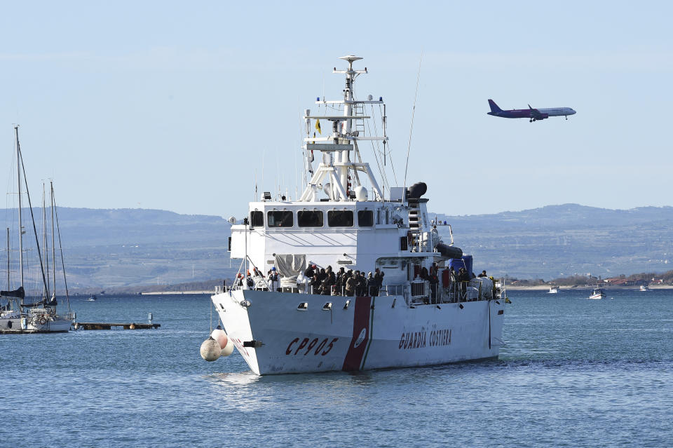 The Italian coast guard ship Peluso approaches the Sicilian harbor of Catania, Italy, Monday, April 17, 2023, with some 300 migrants saved from the sea. (AP Photo/Salvatore Cavalli)