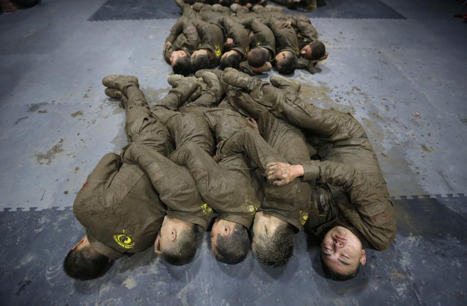 Students hold each other for warmth as they sleep during a break in between high intensity training at Tianjiao Special Guard/Security Consultant camp on the outskirts of Beijing