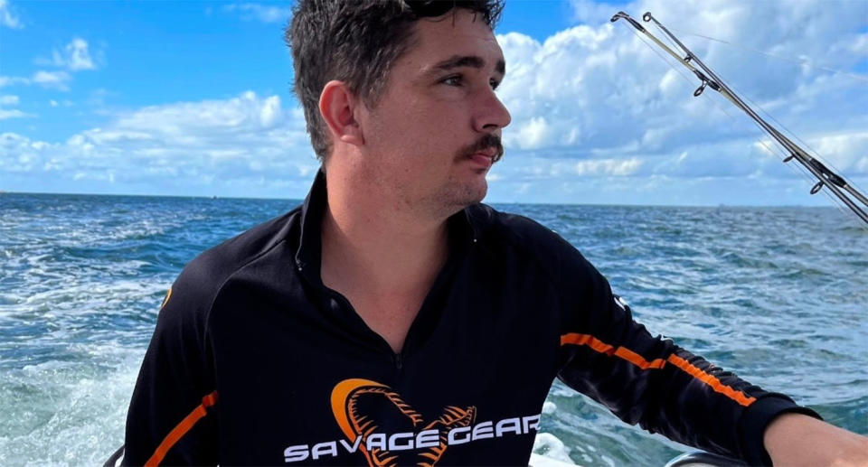 Dylan Clarke wears a black long sleeve top on a day out fishing.