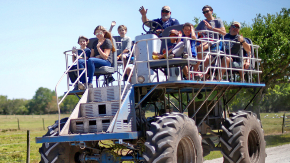 giant swamp buggy with people riding on top