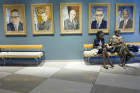 Visitors to the United Nations headquarters sit next to portraits of former secretary-generals ahead of the General Assembly, Friday, Sept. 16, 2022. (AP Photo/Mary Altaffer)