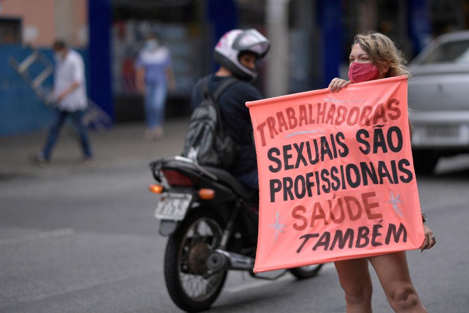 <p>En la imagen, una prostituta sujeta un cartel en el que se lee: “Las trabajadoras sexuales son profesionales. Salud también”. La fotografía fue tomada en la ciudad brasileña de Belo Horizonte. (Foto: Douglas Magno / AFP / Getty Images).</p> 