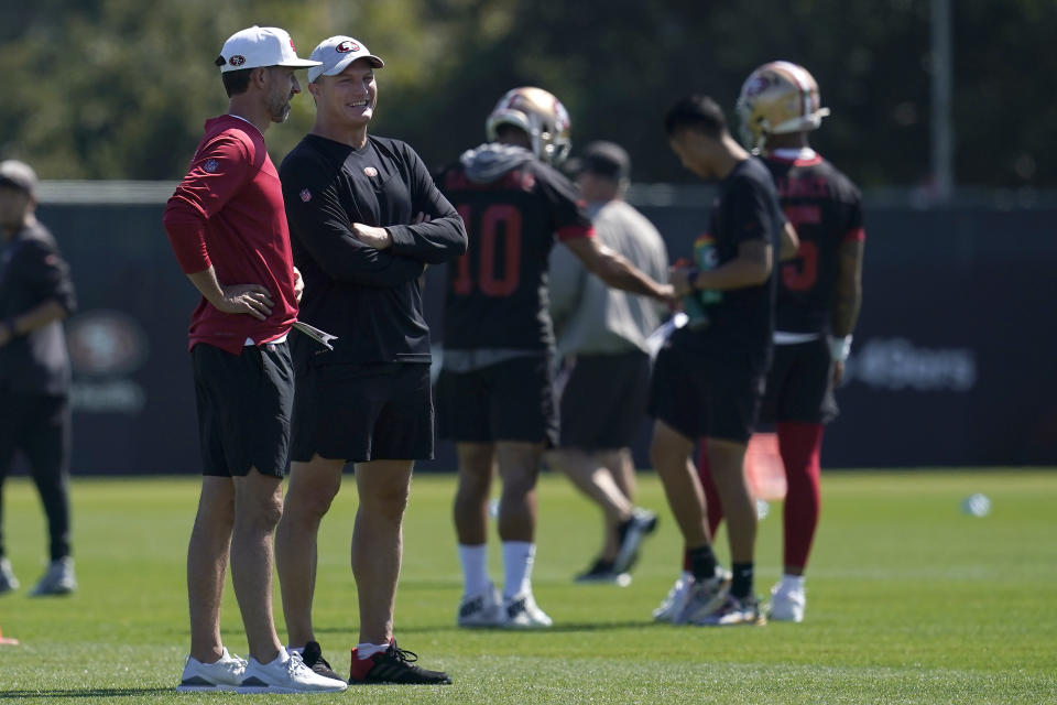 San Francisco 49ers head coach Kyle Shanahan, left, and general manager John Lynch watch as players take part in drills at the NFL football team's practice facility in Santa Clara, Calif., Thursday, Sept. 1, 2022. (AP Photo/Jeff Chiu)