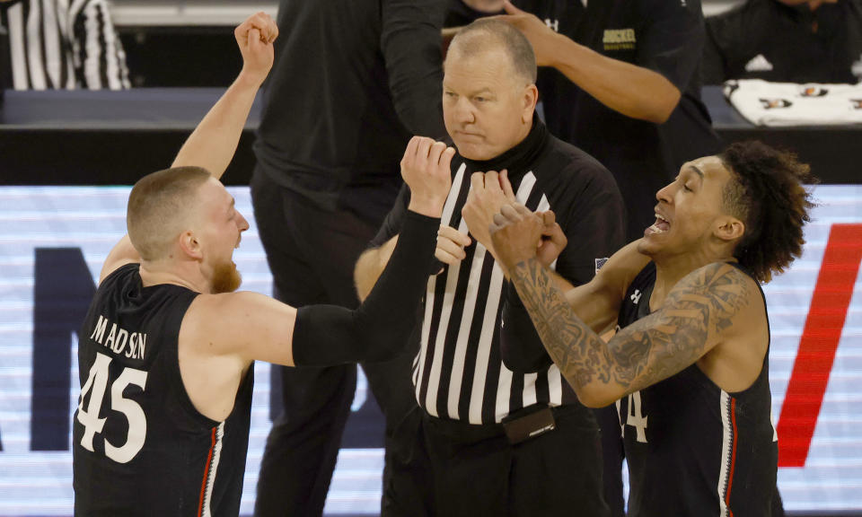 Cincinnati's Mason Madsen (45) and Jeremiah Davenport (24) celebrate following Cincinnati's win over Wichita State after an NCAA college basketball game in the semifinal round of the American Athletic Conference men's tournament Saturday, March 13, 2021, in Fort Worth, Texas. (AP Photo/Ron Jenkins)