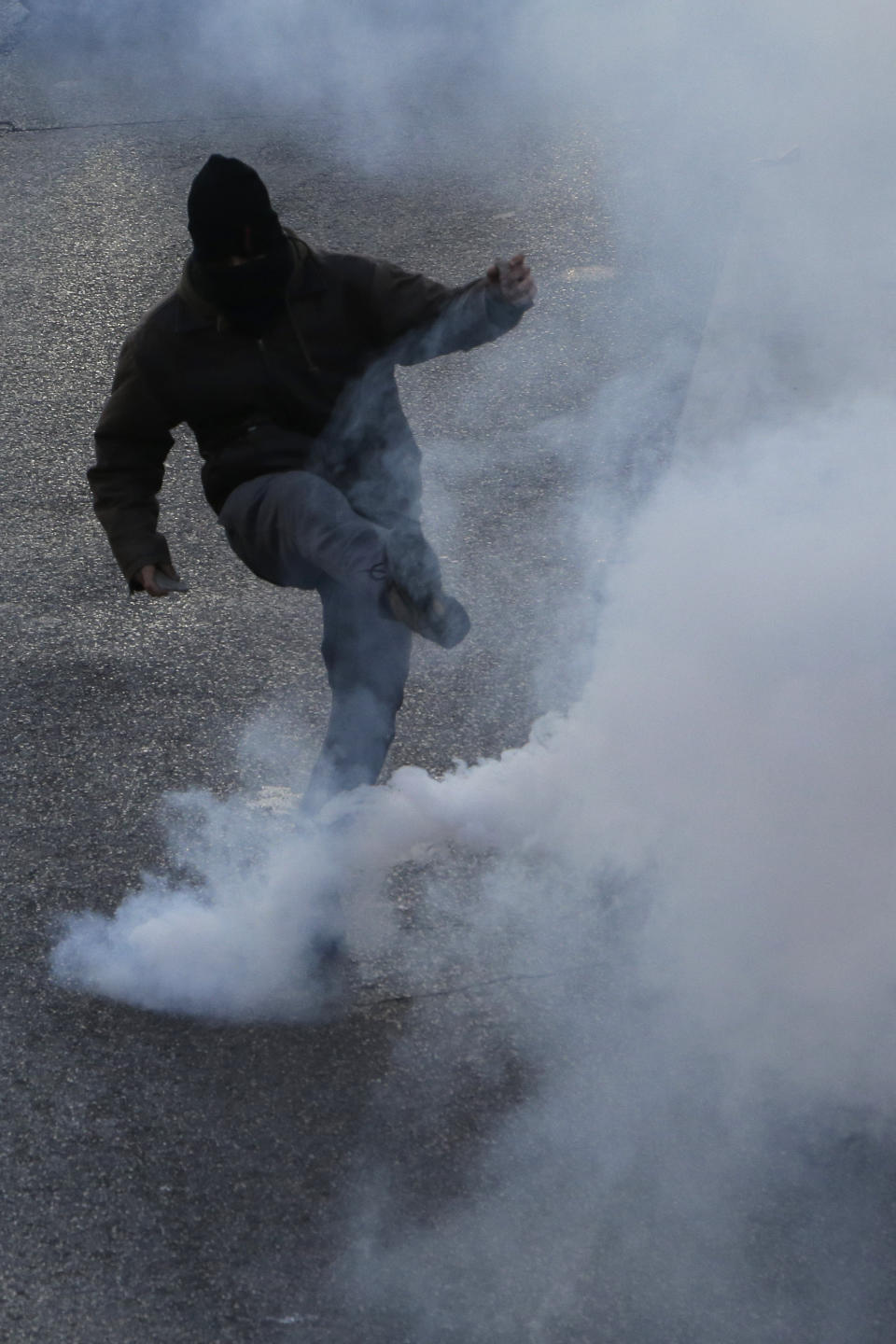 A demonstrator kicks a tear gas during during a protest Saturday, Jan. 19, 2019 in Marseille, southern France. Thousands of yellow vest protesters rallied Saturday in several French cities for a 10th consecutive weekend, despite a national debate launched this week by President Emmanuel Macron aimed at assuaging their anger. (AP Photo/Claude Paris)